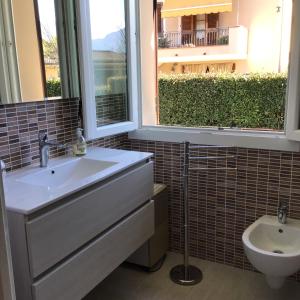 卢卡L olivo的一间带水槽和卫生间的浴室以及窗户。
