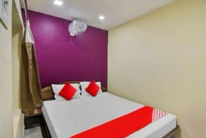 kolkataHOTEL AIRPORT HEAVEN的卧室配有红色和白色的床和紫色墙壁