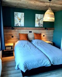 胡法利兹Renée Cense的一间卧室配有一张带蓝色床单和鹿画的床。