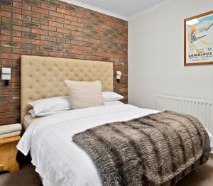 布勒山格里莫斯酒店的一间卧室设有砖墙和一张床