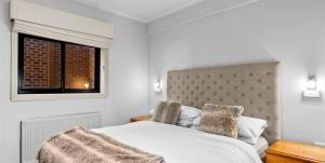 布勒山格里莫斯酒店的卧室配有白色的床和窗户。