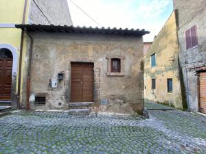 布拉恰诺Il Paiolo Incantato的街道上一座石制建筑,设有木门