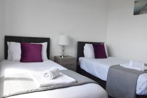 诺里奇Greenfield House的酒店客房,配有两张带毛巾的床
