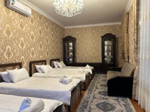 撒马尔罕Guest house Chehra的一间设有四张床和吊灯的客房