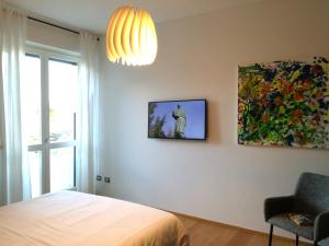阿罗纳Suite 51 Appartamento con terrazzo a 50 mt dal lago - Private Parking的卧室配有一张床,墙上挂有绘画作品