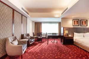 达卡达卡摄政大酒店＆度假村的酒店客房,配有一张床、一张桌子和椅子