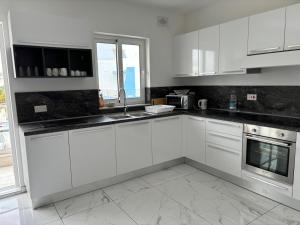 Is-SwieqiSpacious and Cozy Apartment near St Julians - Short Let Apartments Malta的白色的厨房配有白色橱柜和窗户