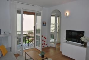 阿罗纳Suite 51 Appartamento con terrazzo a 50 mt dal lago - Private Parking的带沙发和电视的客厅以及阳台。