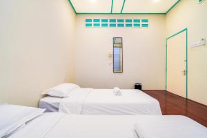 怡保梦想与漫游民宿的配有白色床单的客房内的两张床