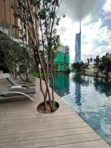 吉隆坡Lucentia Residence by EAS Maju property的坐在游泳池旁木板路上的树