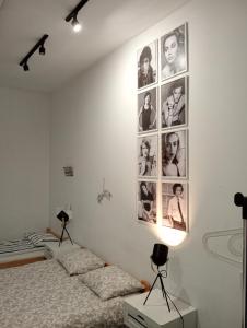 克拉科夫Master Corner Apartment的墙上有两张照片的房间的床铺