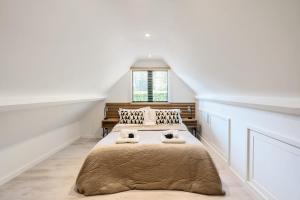 沃金Romantic getaway UK with Private Sauna, King Bed, WiFi 517mbps & EV Charger的阁楼上的卧室配有两张床
