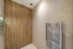 沃金Romantic getaway UK with Private Sauna, King Bed, WiFi 517mbps & EV Charger的浴室设有木墙和淋浴间。