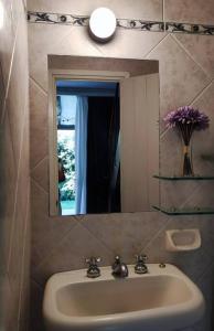 埃斯特角城Aurelia. Dúplex en complejo cerrado en San Rafael的浴室水槽,配有镜子和花瓶