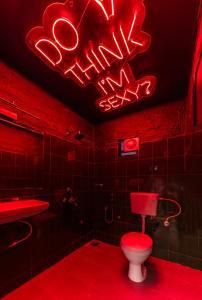 莫尔吉姆Whoopers Boutique Morjim的一间带卫生间和 ⁇ 虹灯标志的浴室