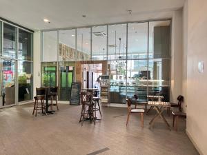 吉隆坡Regalia Suites & Residence studio Apartment by Enjoy your stay的餐厅设有桌椅和窗户。