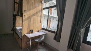 曼谷Urban Jungle Hostel的一间卧室配有书桌、床和窗户。