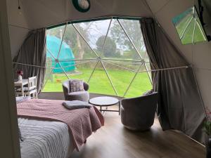 本莱赫Benllech Glamping的帐篷内的卧室设有大窗户