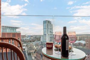 利兹Pass the Keys Granary Wharf Deluxe - balcony and rooftop garden的一张桌子,上面放着两杯酒和一瓶葡萄酒