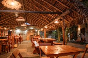 路易斯科雷亚Pousada Villa Coqueiro的餐厅设有木桌和木椅