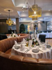 肯梅尔布鲁克林酒店的用餐室配有带白色桌布的桌子