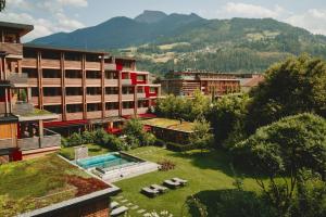 齐勒河谷采尔MalisGarten Green Spa Hotel的一座带游泳池和部分建筑的度假村
