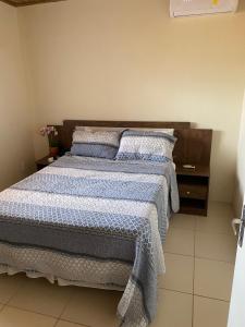 伊塔帕里卡岛维拉克鲁兹Flat Beira Mar no Condomínio Diver的一间卧室配有一张带蓝色和白色床单及枕头的床。