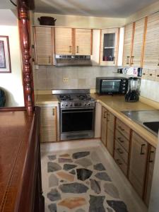 MéridaConfortable Apartamento的厨房配有木制橱柜和炉灶烤箱。