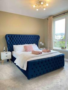 格拉斯哥The Naburn - 3 Bed House with Free Parking & Close to City Centre的卧室内的一张带蓝色床头板的大床