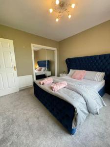 格拉斯哥The Naburn - 3 Bed House with Free Parking & Close to City Centre的一间卧室配有蓝色的床和粉红色枕头