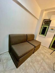 安塔利亚Cozy Midtown Flat in Antalya T2的窗户房间里一张棕色的沙发