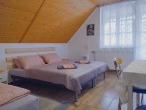 博加奇Viola Apartmanház的一间卧室设有两张床和木制天花板