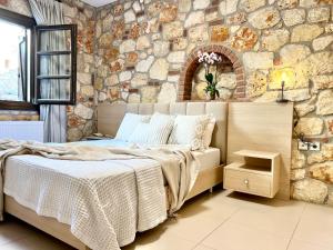 普萨克迪亚Boutique Stone House的一间卧室设有一张床和石墙