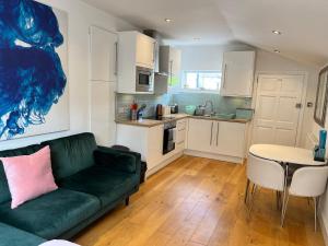切辛顿Lovely Annexe near Surbiton/Kingston, SW London的一间带绿色沙发的客厅和一间厨房