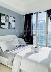 马尼拉The Bahamas and Maldives Suites at Azure Residences near Manila Airport的卧室设有一张白色的床和大窗户