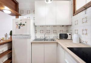 坎德拉里亚Costa Azul apartamento con vista的白色的厨房配有水槽和冰箱