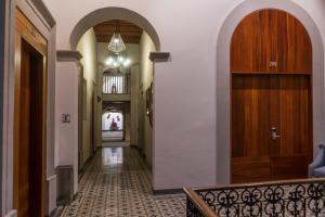 克雷塔罗马德罗酒店的走廊上设有拱门,走廊上设有门