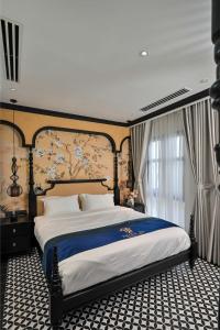 Bạc LiêuThiên Ân Boutique Hotel的一间卧室配有一张带蓝色毯子的大床