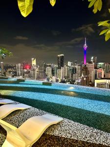吉隆坡AXON RESIDENCE AT BUKIT BiNTANG KUALA LAMPUR的游泳池,晚上可欣赏到城市美景