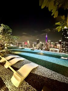 吉隆坡AXON RESIDENCE AT BUKIT BiNTANG KUALA LAMPUR的游泳池,晚上可欣赏到城市景观