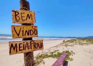 纳韦甘蒂斯Casa a 200 mts da praia - prox Aeroporto NVG - CASA DA MEIA PRAIA的海滩上的一个杆上的标志
