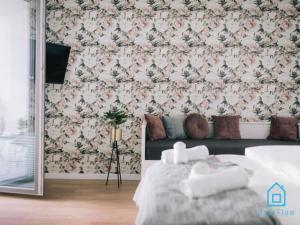格但斯克White Apartment的一间卧室配有一张床和花卉壁纸