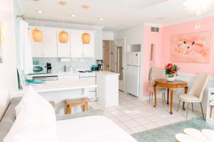 泰比岛Palm Peach Tybee - Balcony - Oceanview "It's like, really pretty!"的厨房设有粉红色的墙壁和桌椅