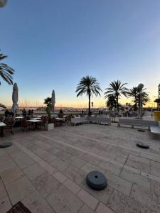 坎帕斯蒂利亚Estudio en Palma de Mallorca a metros de la playa的庭院设有桌子和长椅,棕榈树