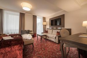 巴特霍夫加施泰因Hotel Norica - Thermenhotels Gastein mit dem Bademantel direkt in die Therme的酒店客房设有沙发和客厅。