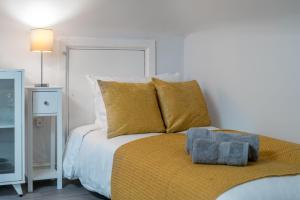 伦敦Cosy 4th Floor studio apartment in Brick Lane的一间卧室配有一张带黄色枕头的床