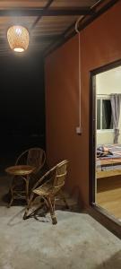 Phumĭ Chroŭy SvayCare Rock Guesthouse的一间设有两把椅子、一面镜子和一张床的房间
