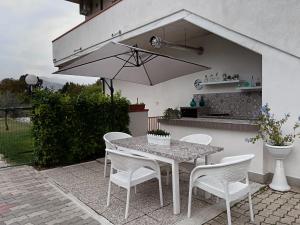 苏尔莫纳Parco delle Rose的庭院配有桌椅和遮阳伞。