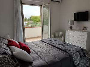 苏尔莫纳Parco delle Rose的一间卧室配有一张带红色枕头的床和一扇窗户