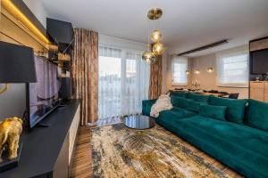 锡尼Apartman Bono的客厅配有绿色沙发和桌子